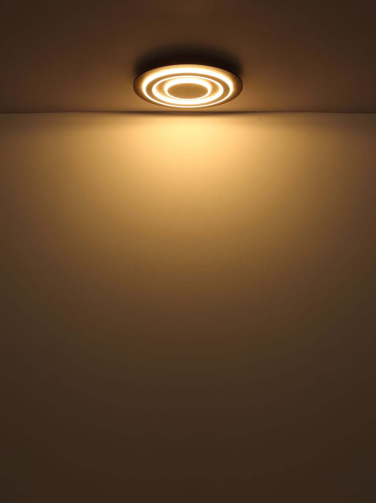 Moderne Deckenleuchte mit kreisförmigem Design, von unten betrachtet, strahlt warmes Licht aus.