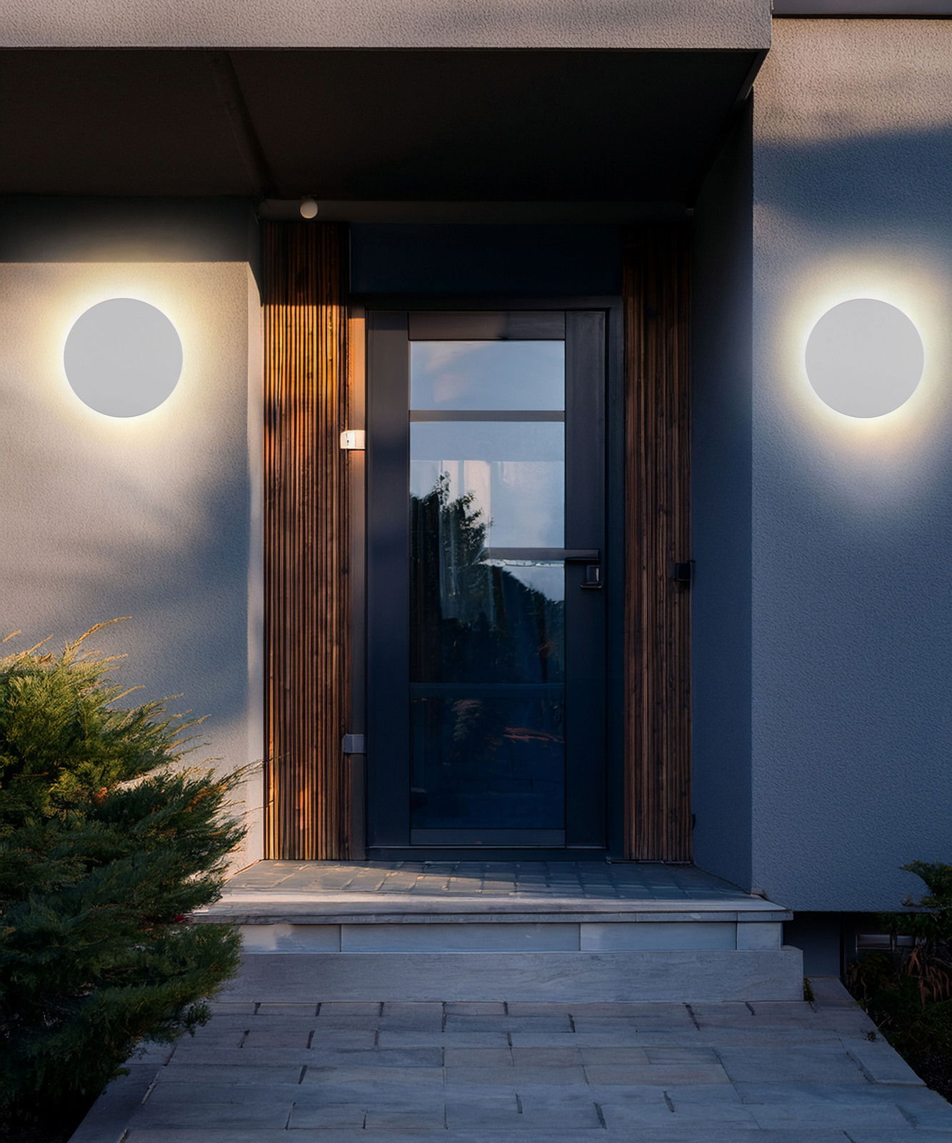 Moderne LED-Außenwandleuchte an einer Hausfassade, frontal betrachtet, mit warmem Lichtschein.