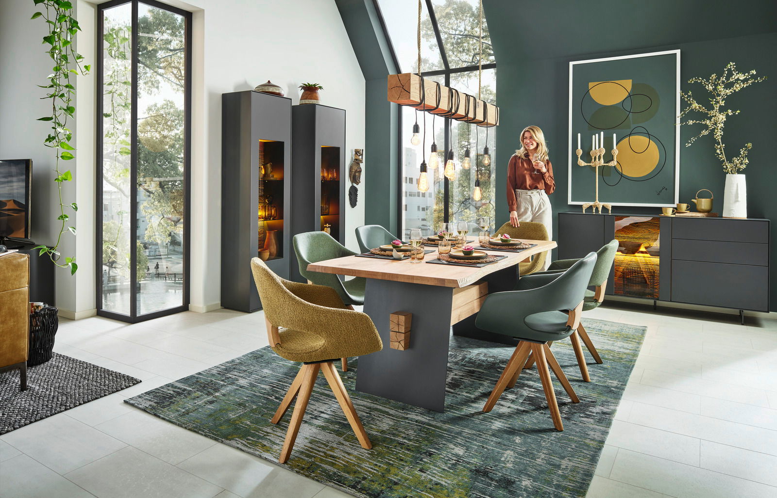 Moderner Esstisch aus Holz mit dunklen Akzenten, umgeben von stilvollen Stühlen in einem eleganten Esszimmer mit großen Fenstern und dekorativer Beleuchtung. Perspektive: seitlich.