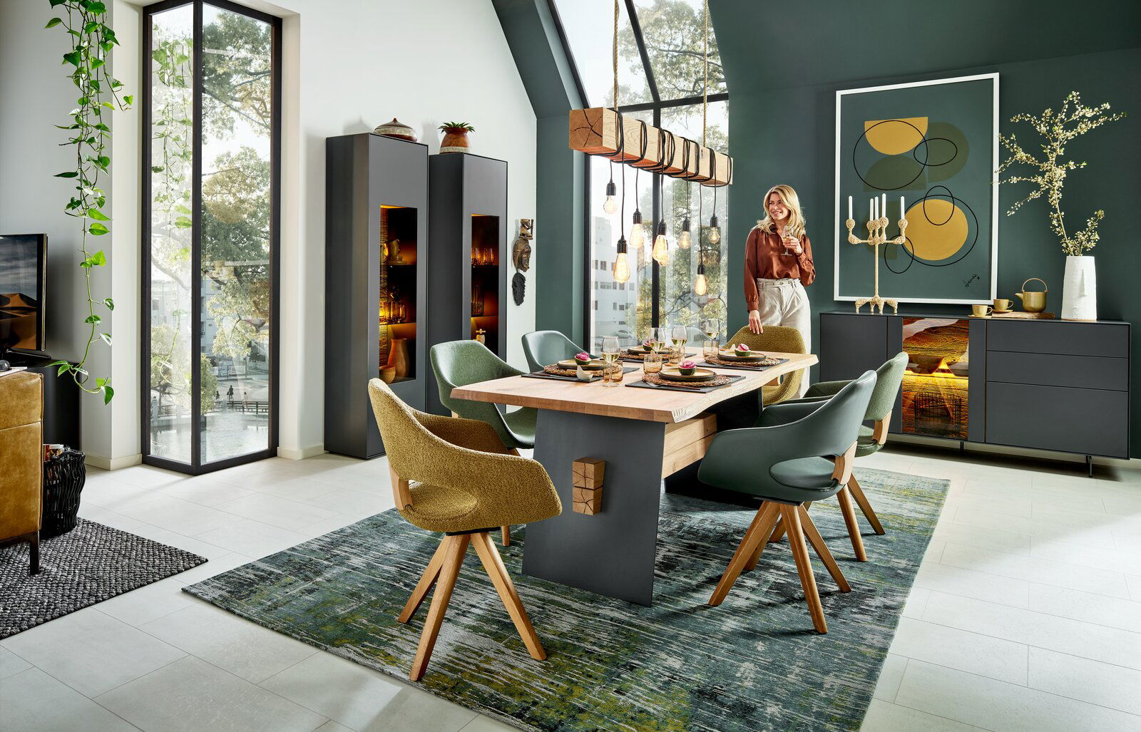 Moderner Esstisch aus Holz mit dunklen Akzenten, umgeben von stilvollen Stühlen in einem eleganten Esszimmer mit großen Fenstern und dekorativer Beleuchtung. Perspektive: seitlich.