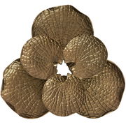 Goldenes Wandornament in Form von überlappenden Blütenblättern mit strukturierter Oberfläche, Frontalansicht.