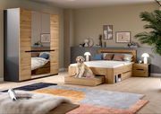 Modernes Schlafzimmer-Set in Eiche-Optik mit Bett inklusive Schubladen, Nachttisch und Kleiderschrank mit Spiegeltüren, fotografiert in frontaler Raumansicht aus leicht erhöhter Perspektive