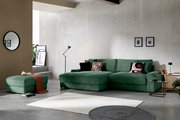 Grünes, modernes Ecksofa mit Récamiere in Cordoptik im Wohnzimmer-Setting, Frontansicht leicht schräg von links, mit passendem Hocker, Kissen und Beistelltischen