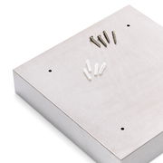 Schlüsselkasten aus Metall in schräger Draufsicht mit Schrauben und Dübeln auf der Oberseite.