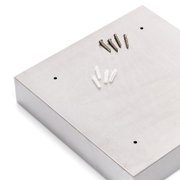 Schlüsselkasten aus Metall in schräger Draufsicht mit Schrauben und Dübeln auf der Oberseite.