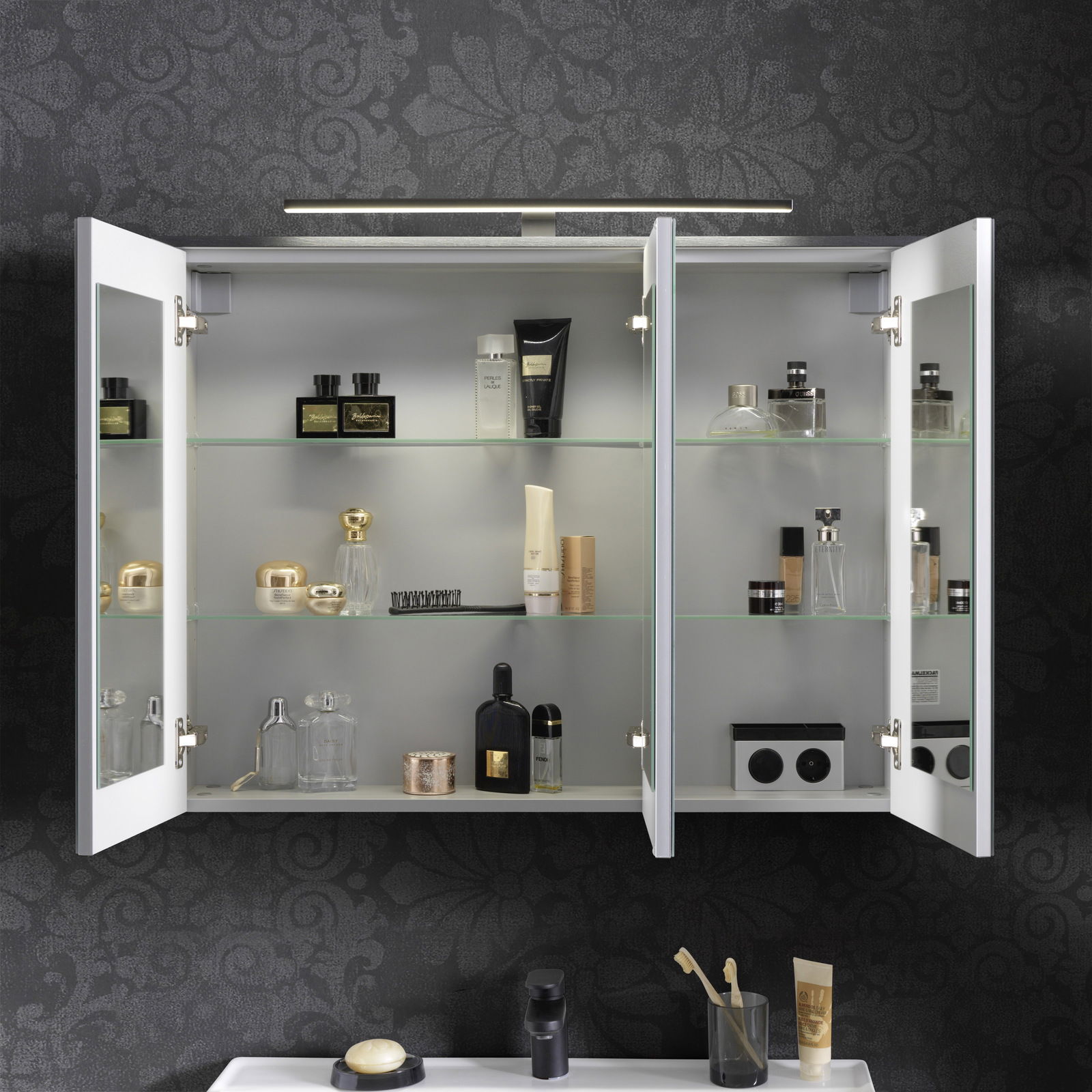 Spiegelschrank mit geöffneten Türen, gefüllt mit Kosmetikartikeln, aus frontaler Perspektive.