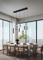 Moderne Pendelleuchte über einem Esstisch in einem eleganten, lichtdurchfluteten Raum mit großen Fenstern, seitliche Perspektive.