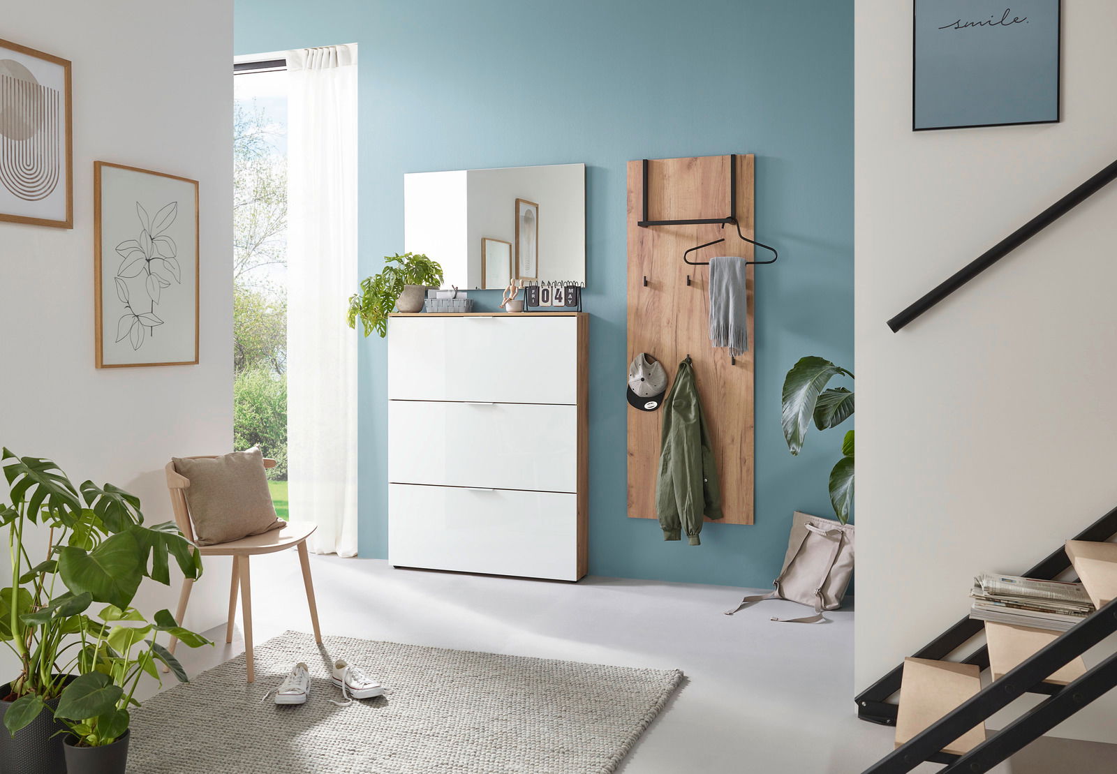 Moderner Eingangsbereich mit Garderobenpaneel und Schuhschrank in hellem Holz und Weiß, seitliche Perspektive