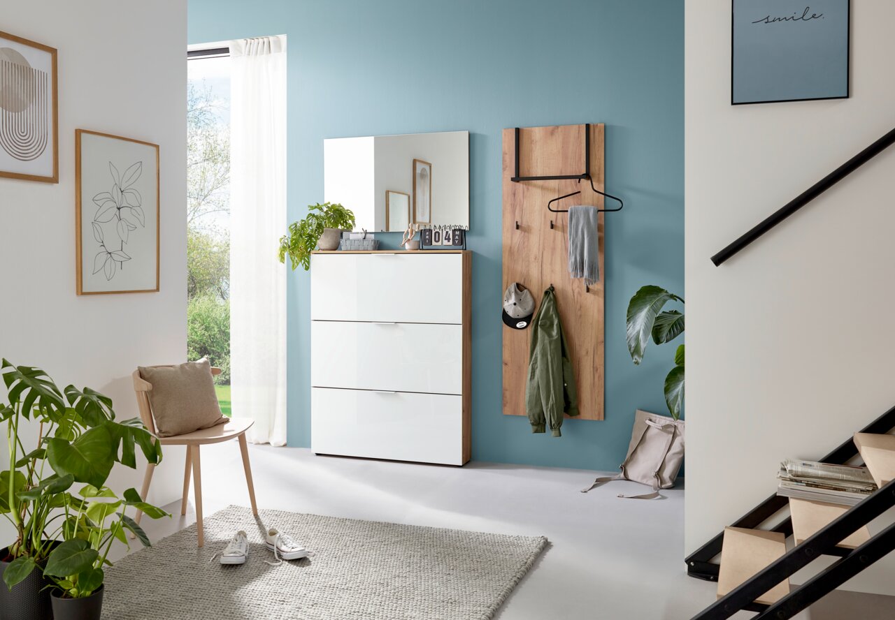 Moderner Eingangsbereich mit Garderobenpaneel und Schuhschrank in hellem Holz und Weiß, seitliche Perspektive