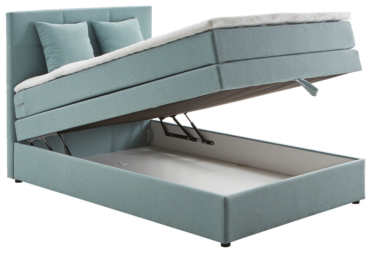 Boxspringbett in hellblauem Stoff mit hochgeklappter Matratze, die den Stauraum darunter zeigt. Perspektive von der Seite.