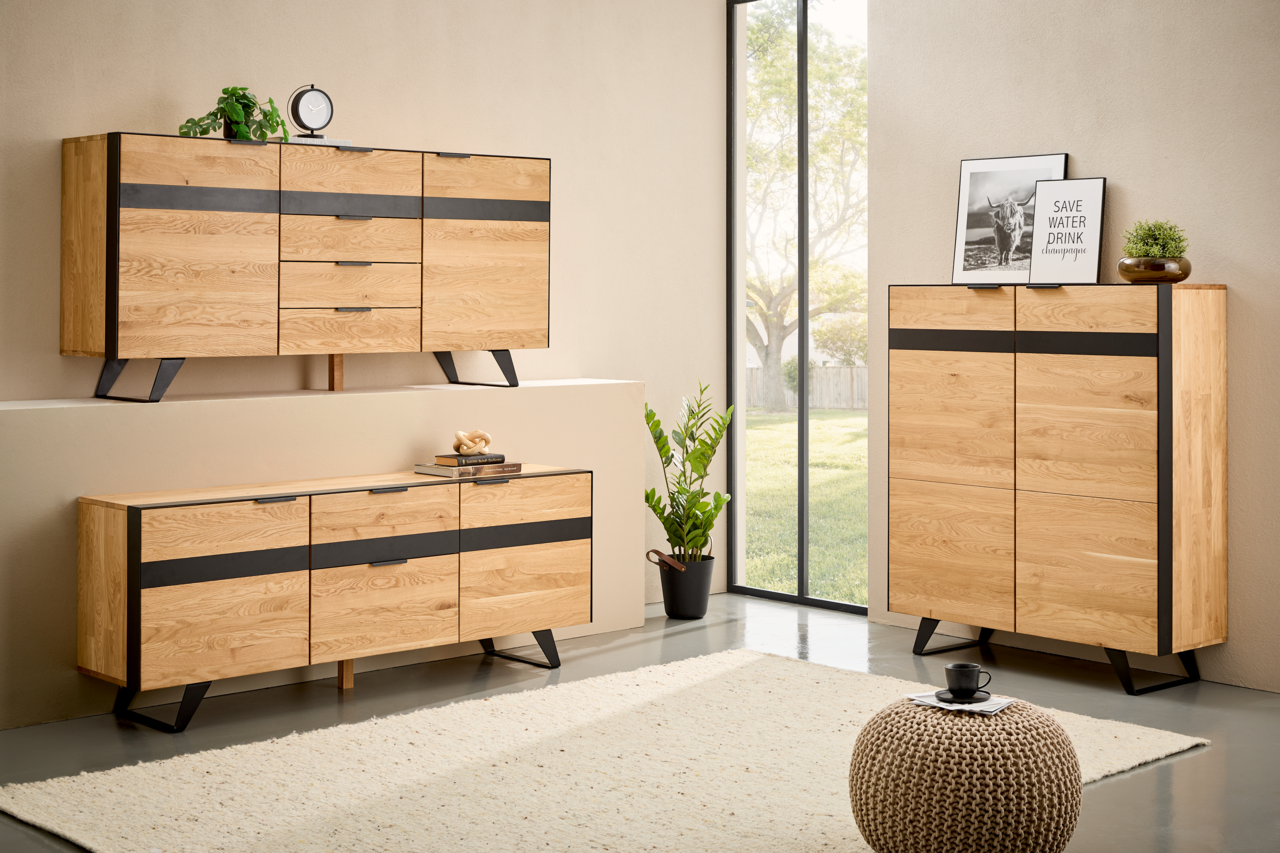 Moderne Wohnzimmermöbel aus Holz mit schwarzem Akzent, bestehend aus einem Sideboard, Highboard und TV-Lowboard, in einem hellen Raum mit Blick auf den Garten.