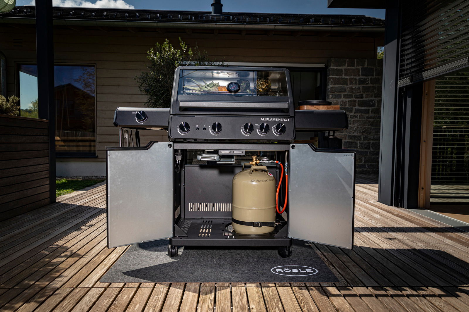 Frontansicht des Gasgrills Allflame Hero 4 mit geöffneten Türen, sichtbarer Gasflasche und Grillfläche.