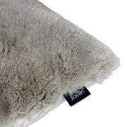 Nahaufnahme eines weichen, grauen Kunstfellkissens mit Joop-Label.