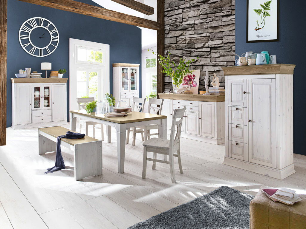 Esszimmer mit rustikalem Holztisch, Stühlen und Bänken in heller Holzoptik, umgeben von passenden Schränken und Vitrinen. Perspektive: Frontalansicht auf den Tisch und die Stühle.