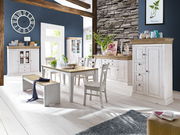 Esszimmer mit rustikalem Holztisch, Stühlen und Bänken in heller Holzoptik, umgeben von passenden Schränken und Vitrinen. Perspektive: Frontalansicht auf den Tisch und die Stühle.