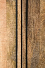 Nahaufnahme von Holzoberflächen mit vertikalen schwarzen Streifen, perspektivisch von vorne betrachtet.
