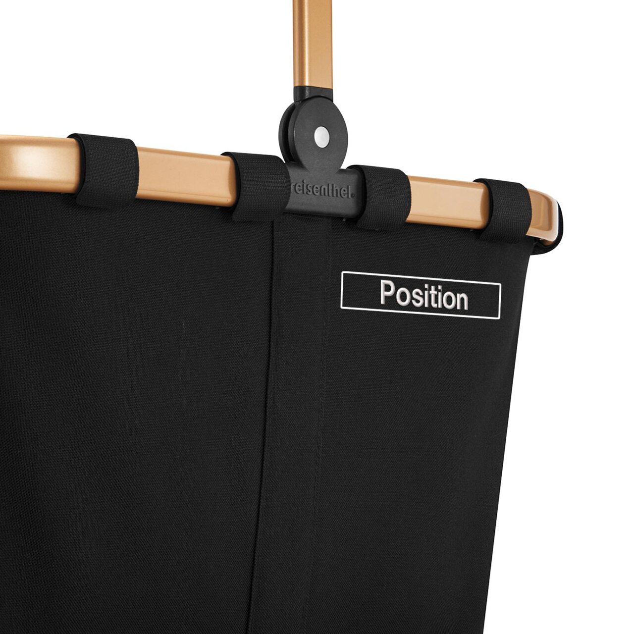 Nahaufnahme eines schwarzen Carrybag mit goldfarbenem Rahmen, seitliche Perspektive