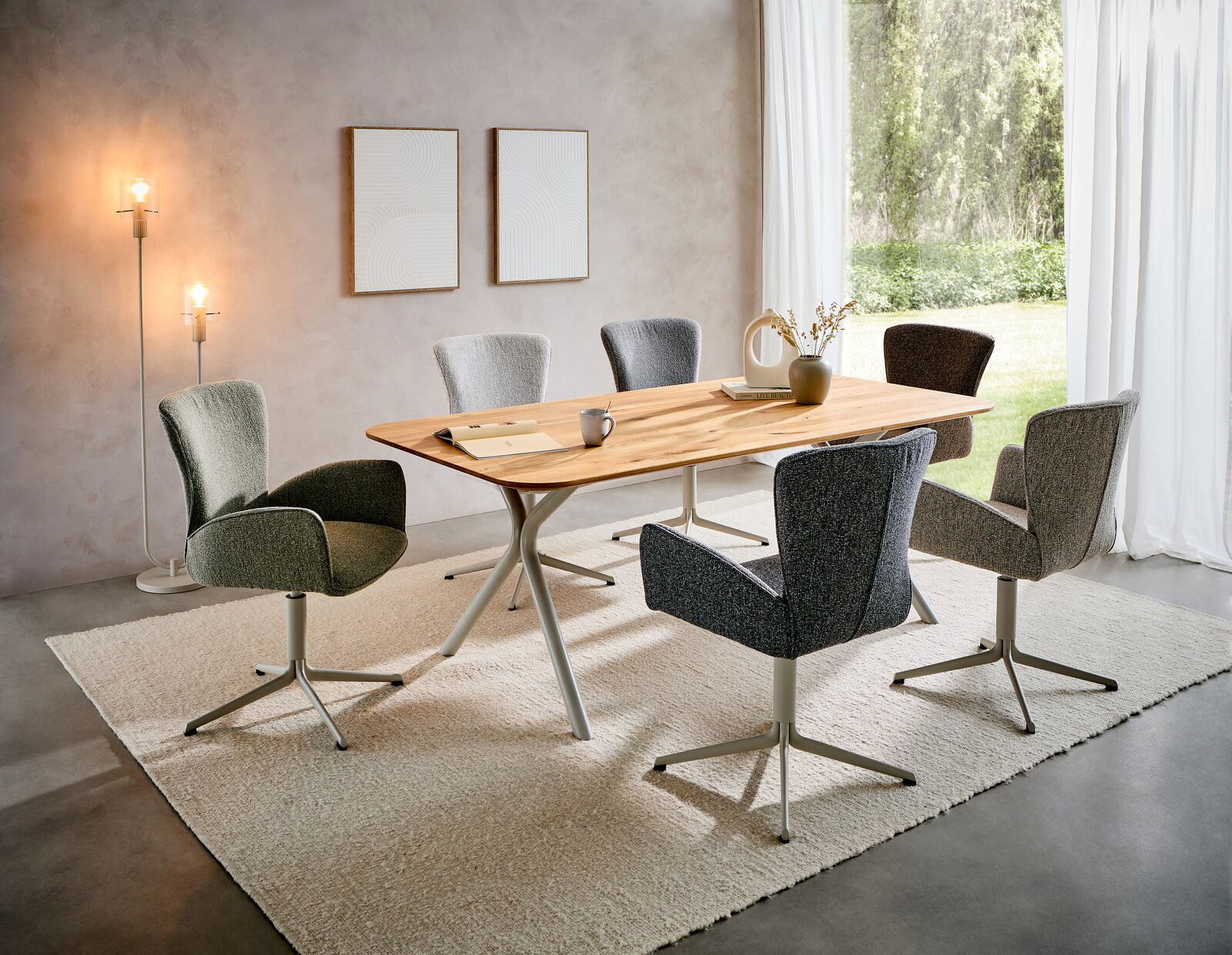 Valdera Armlehnstuhl KIARA Esszimmer mit modernem Esstisch aus Holz und sechs gepolsterten Armlehnstühlen in verschiedenen Farben, seitliche Perspektive.