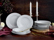 Weißes Porzellan-Geschirrset mit Reliefrand (Teller und Schalen) auf dunklem Holztisch dekoriert mit Kerzen, Blumen und goldenem Besteck, fotografiert in leicht erhöhter Frontansicht.
