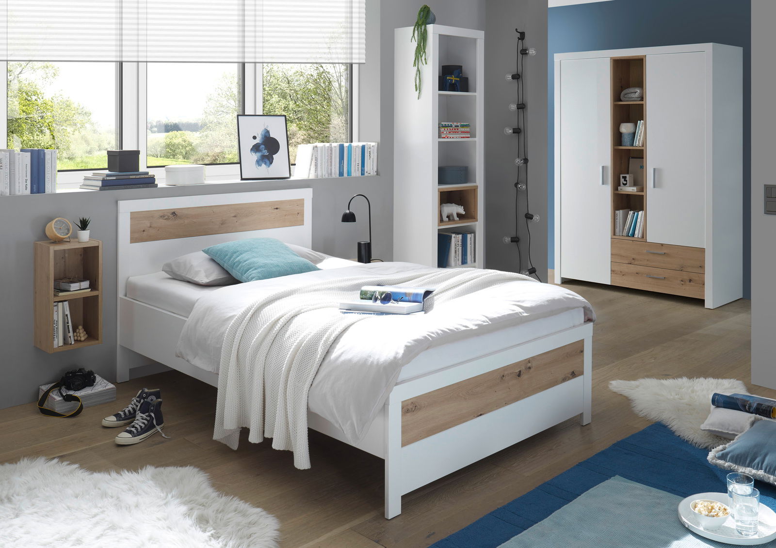 Modernes Schlafzimmer mit Standregal, Bett und Kleiderschrank in Holz- und Weißtönen, seitliche Perspektive