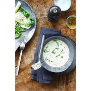 Saucenlöffel Nuova auf einem Holztisch neben einer Schüssel mit Kräutersauce, von oben betrachtet.