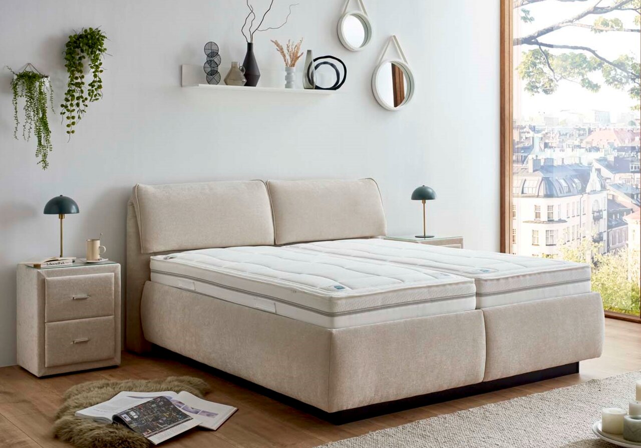 Modernes Polsterbett in einem hellen Schlafzimmer mit Stadtblick, seitliche Perspektive