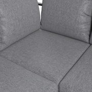 Nahaufnahme eines grauen Lounge-Sofas mit weichen Kissen und texturierter Oberfläche.