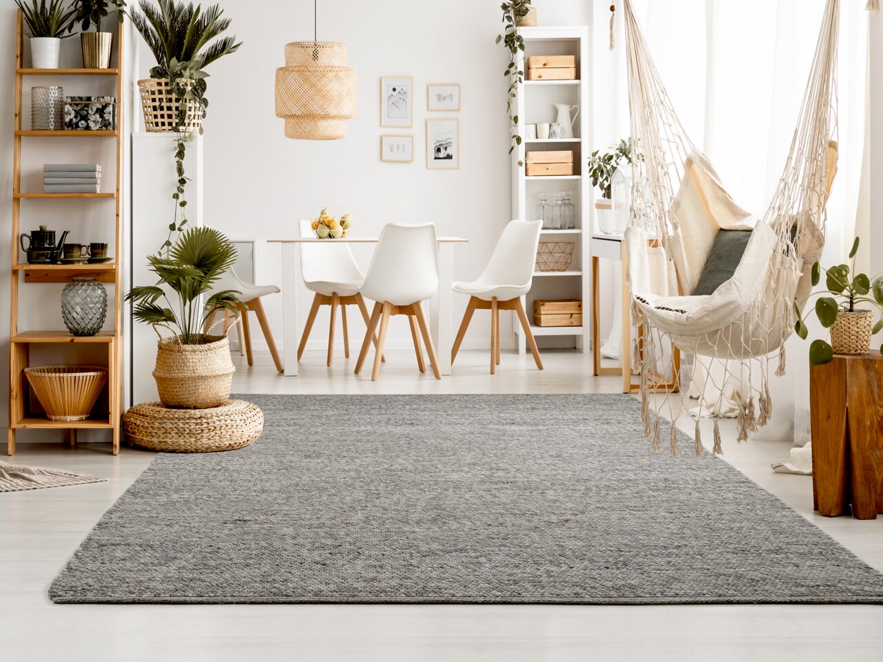 OCI Handweb Teppich FAVORIT Grauer Handweb Teppich in modernem Wohnzimmer mit Hängesessel und Pflanzen, aus der Perspektive des Raumes fotografiert.