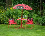 Kinder Gartenmöbelset mit Marienkäfer-Design, bestehend aus zwei Stühlen, einem Tisch und einem Sonnenschirm, aufgestellt auf einer grünen Wiese mit Blick von vorne.