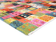 Bunter Designer Teppich mit Patchwork-Muster, perspektivisch von der Seite fotografiert.