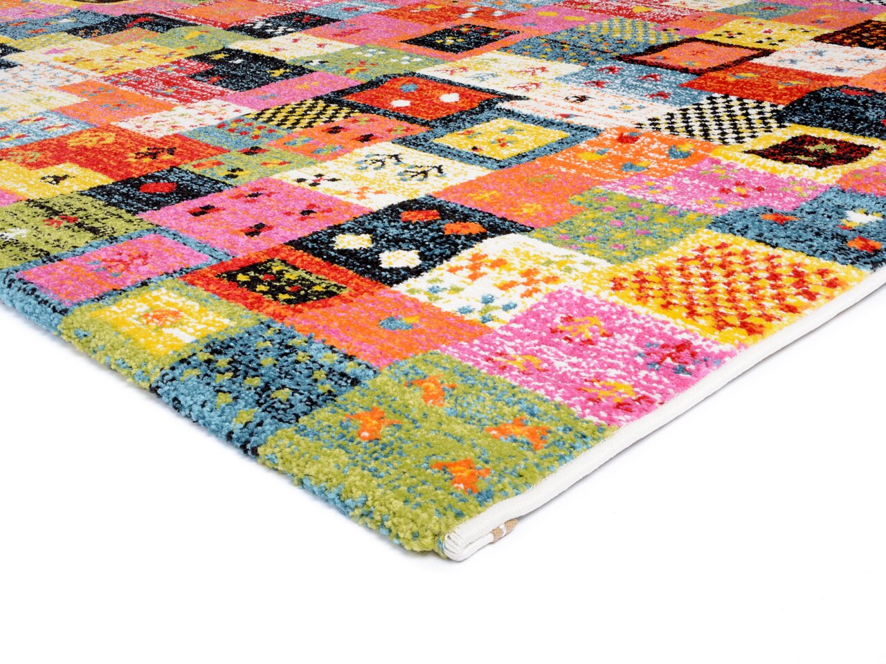 Bunter Designer Teppich mit Patchwork-Muster, perspektivisch von der Seite fotografiert.