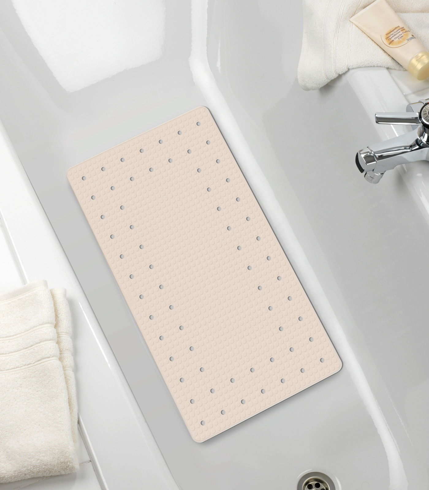 Beige Wanneneinlage Mirasol in einer Badewanne, von oben fotografiert, mit Handtüchern und Pflegeprodukten am Rand.