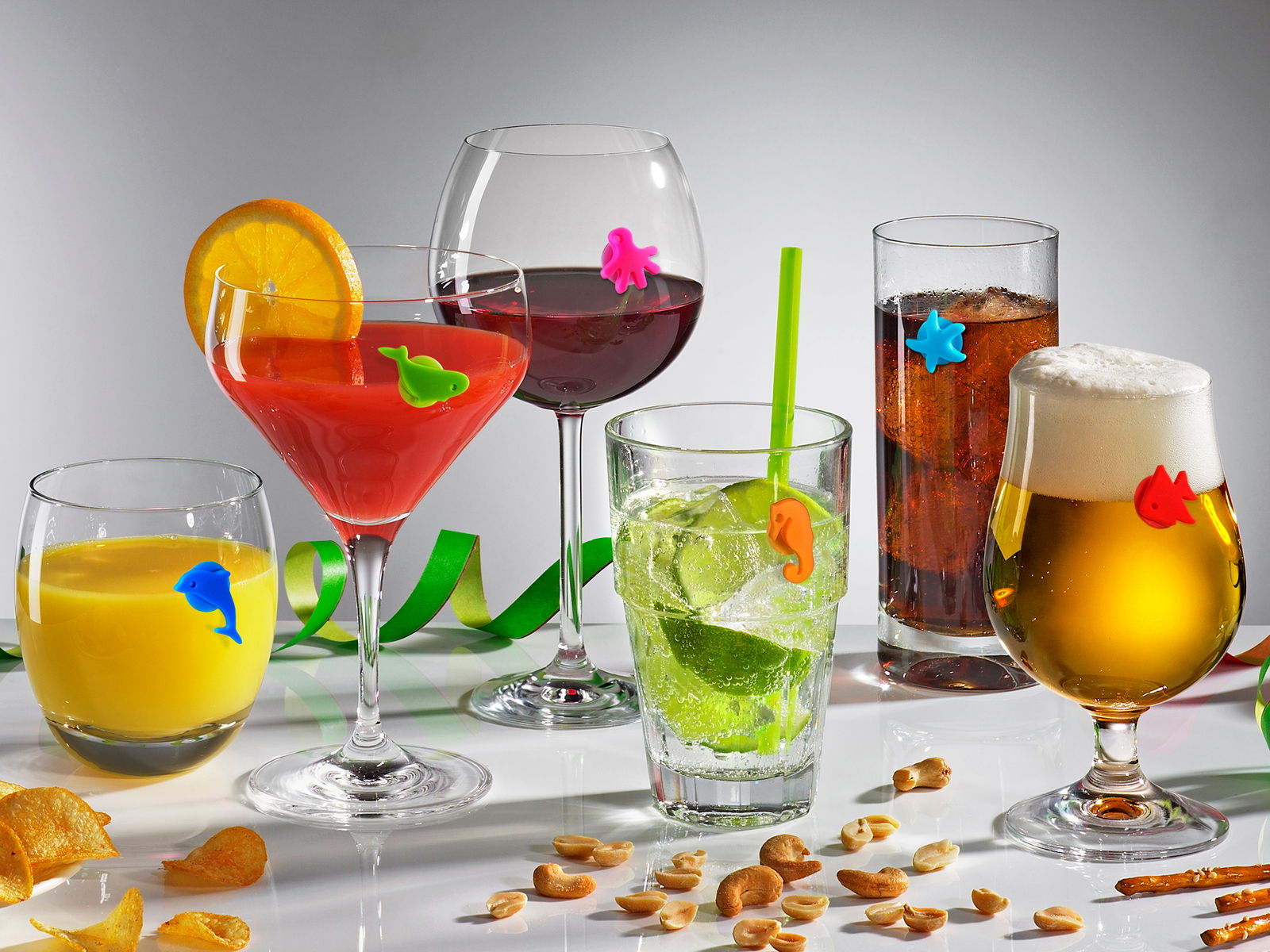 Verschiedene Gläser mit bunten Glasmarkern in Form von Meeresmotiven, frontal fotografiert.