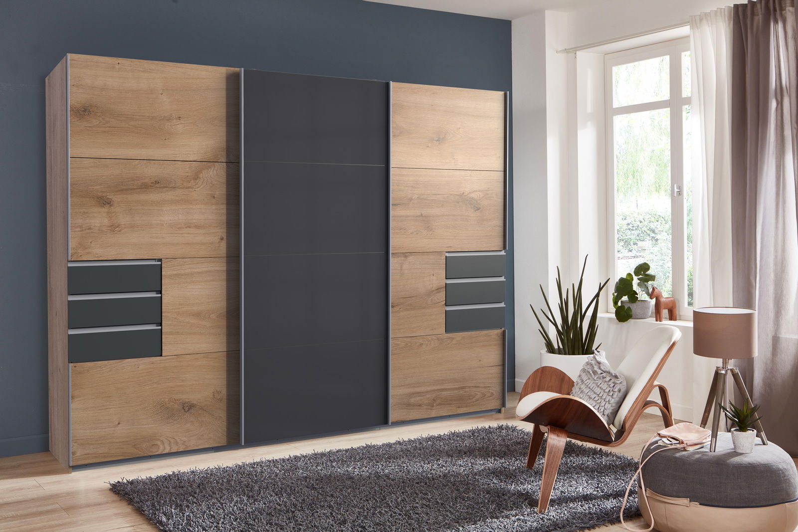Z2 Hangende kast met 3 deuren SAIGON Moderner Schwebetürenschrank mit drei Türen in Holzoptik und grauen Elementen, frontal fotografiert in einem stilvoll eingerichteten Raum.