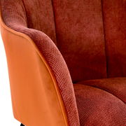 Nahaufnahme eines Armlehnstuhls in Rot- und Orangetönen, seitliche Perspektive