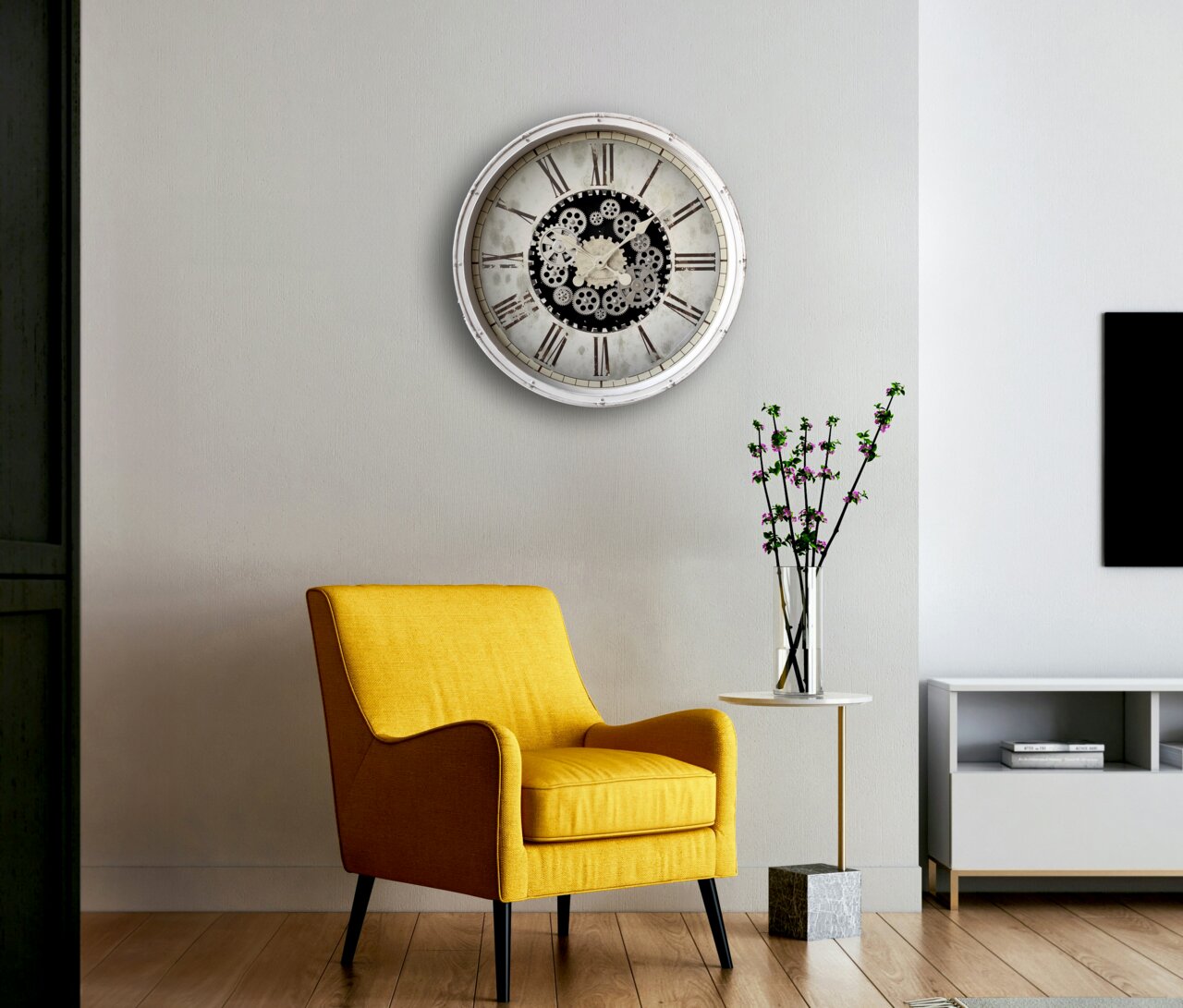 Wanduhr mit Zahnrädern und römischen Ziffern, an einer hellen Wand über einem gelben Sessel und einem kleinen Tisch mit Vase, aus frontaler Perspektive.