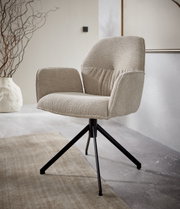 Moderne fauteuil met beige stoffen bekleding en een zwart metalen frame, gezien vanaf de zijkant.