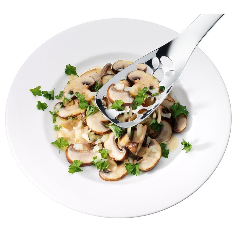 Servierlöffel Nuova 25cm aus Edelstahl, von oben fotografiert, über einem Teller mit Pilzen und Petersilie.