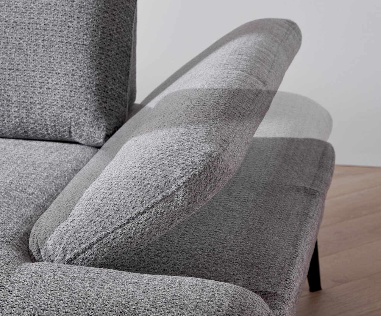 Close-up van een grijze longchair-set met verstelbare rugleuning, gezien vanaf de zijkant.