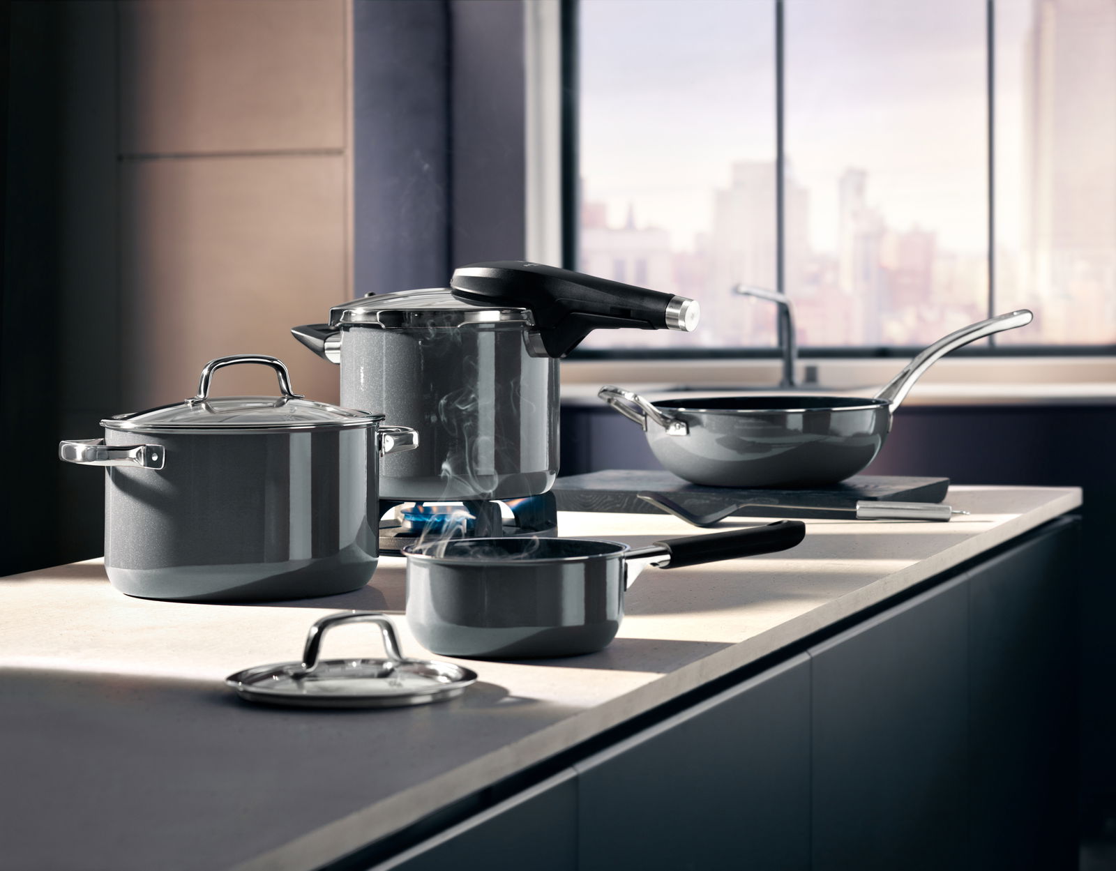 Moderne Küche mit einem Schnellkochtopf Fusiontec Perf und weiteren Töpfen und Pfannen auf einer Arbeitsplatte, seitliche Perspektive.