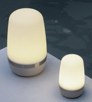 Zwei LED-Outdoorleuchten SPIRIT von Blomus, eine größere und eine kleinere, auf einer hellen Oberfläche neben einem Pool, seitliche Perspektive.