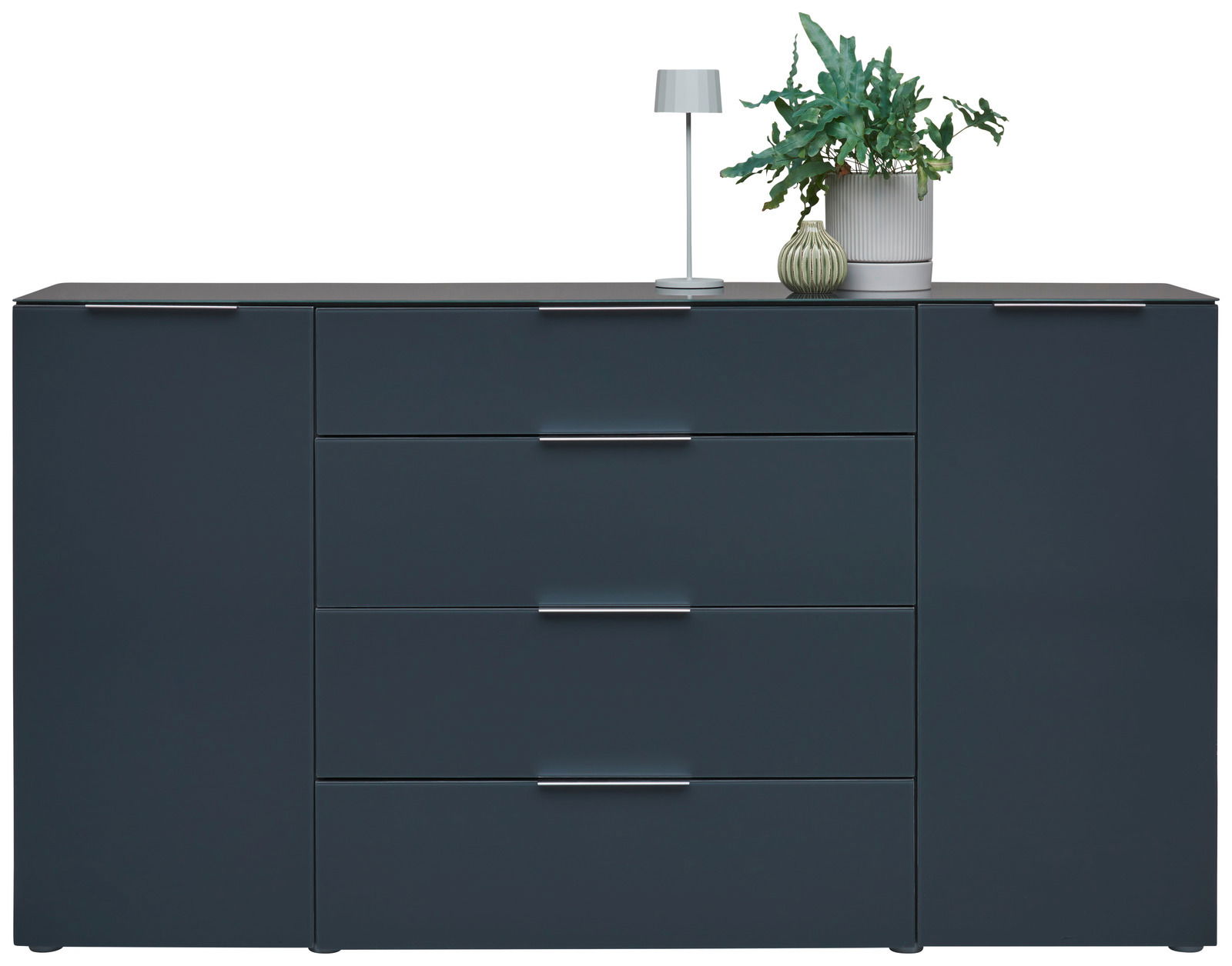 Modernes Sideboard in dunklem Blau mit vier Schubladen und zwei Türen, dekoriert mit einer Tischlampe und Pflanzen, Frontalansicht.