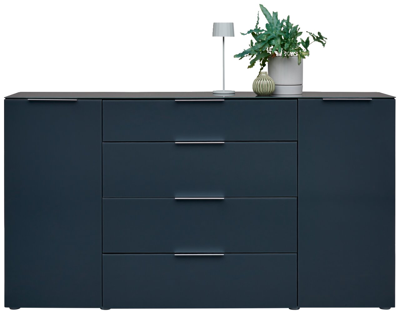 Modern dressoir in donkerblauw met vier lades en twee deuren, versierd met een tafellamp en planten, vooraanzicht.