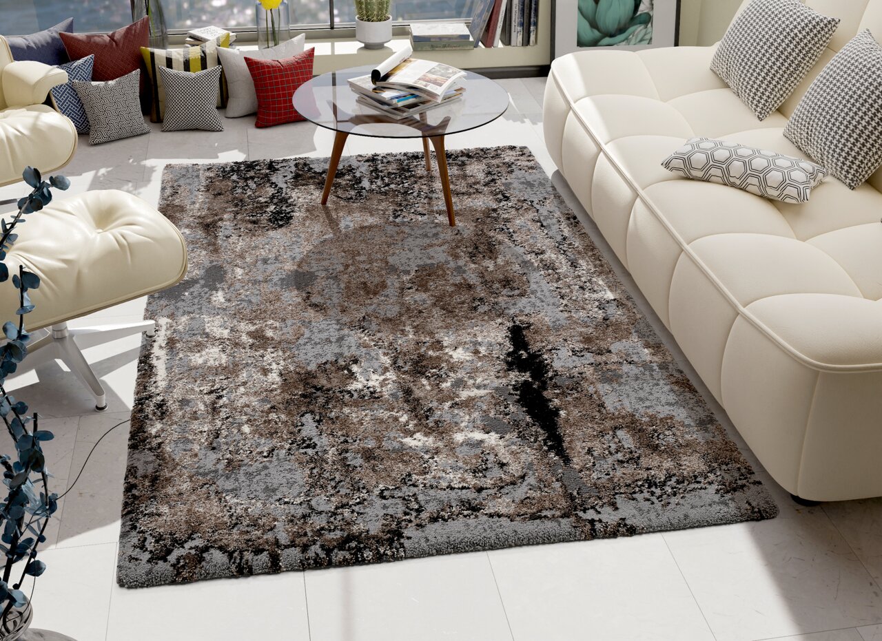 OCI Designer Teppich JUWEL Designer Teppich in einem modernen Wohnzimmer, umgeben von einem weißen Sofa und einem Glastisch, aus der Vogelperspektive betrachtet.