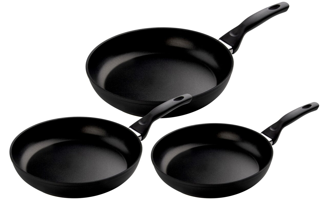 Dreiteiliges Pfannenset in schwarzer Farbe, bestehend aus drei unterschiedlich großen Pfannen mit Griffen, aus der Vogelperspektive fotografiert.