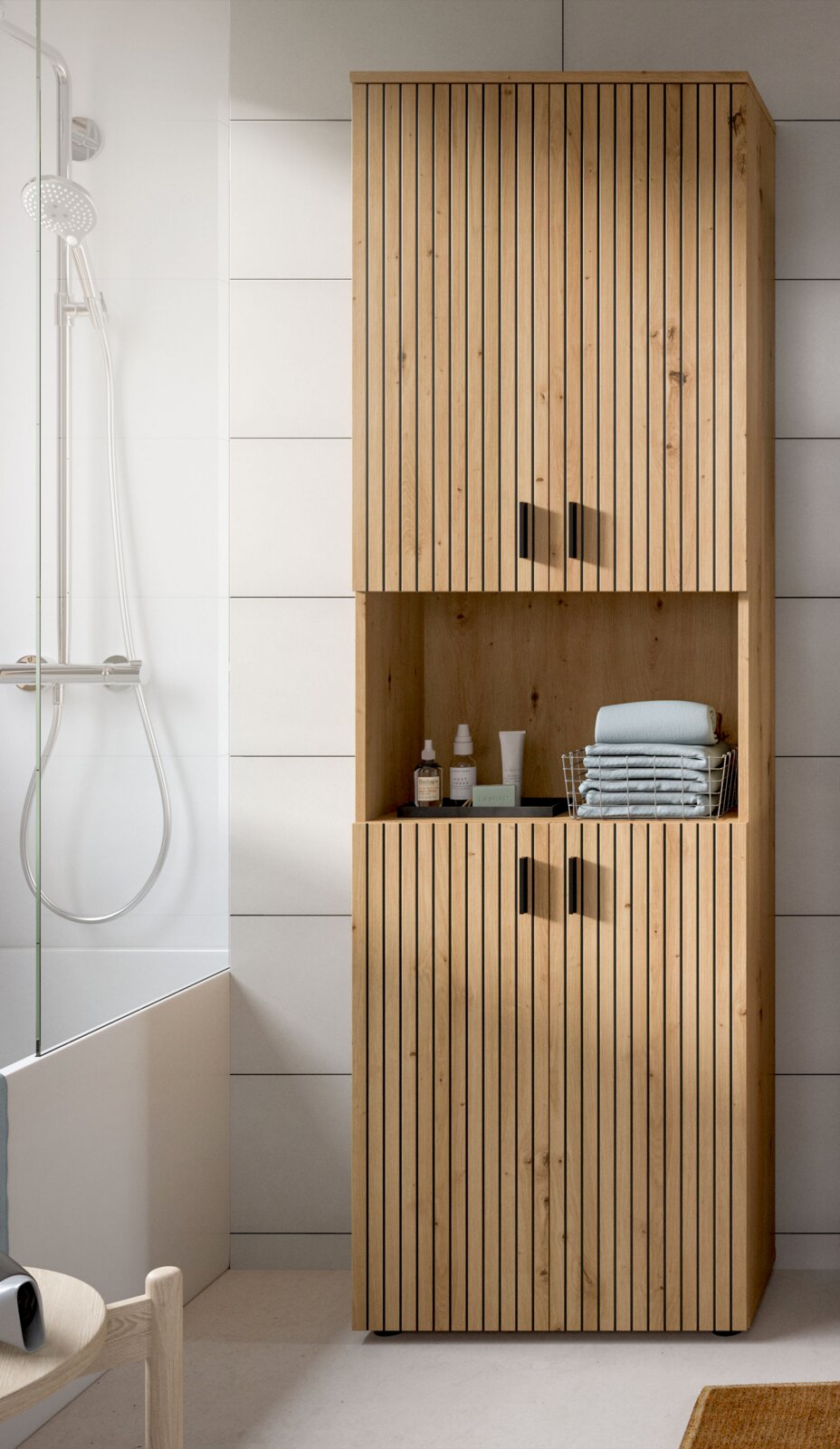 Hoher Badezimmerschrank aus Holz mit vertikaler Lamellenfront, zwei Türen oben und unten sowie offenem Mittelregal mit Handtüchern und Pflegeprodukten, frontal aus leichter Seitenperspektive fotografiert.