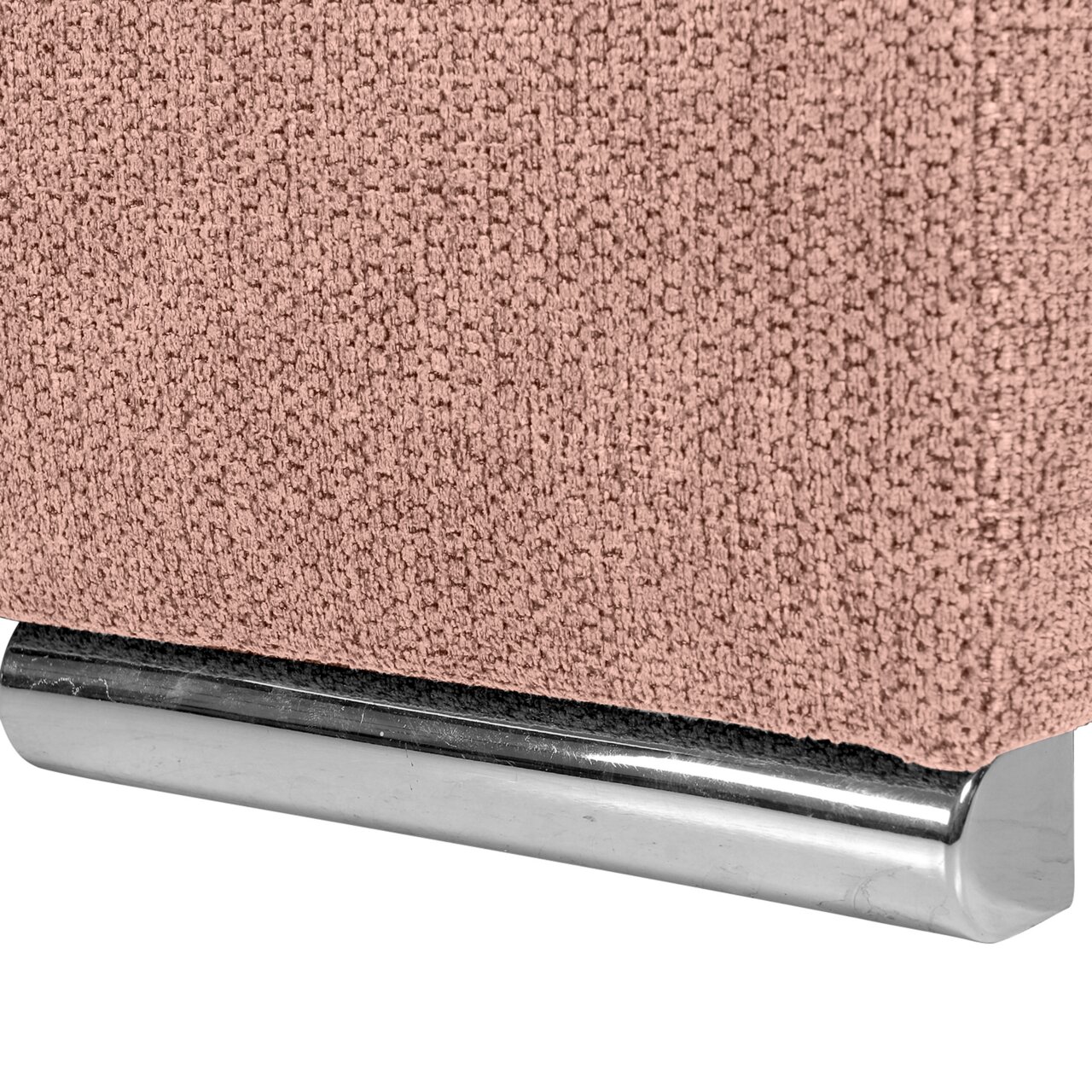 Nahaufnahme einer rosa strukturierten Stoffoberfläche mit einem glänzenden, metallischen Sockel.