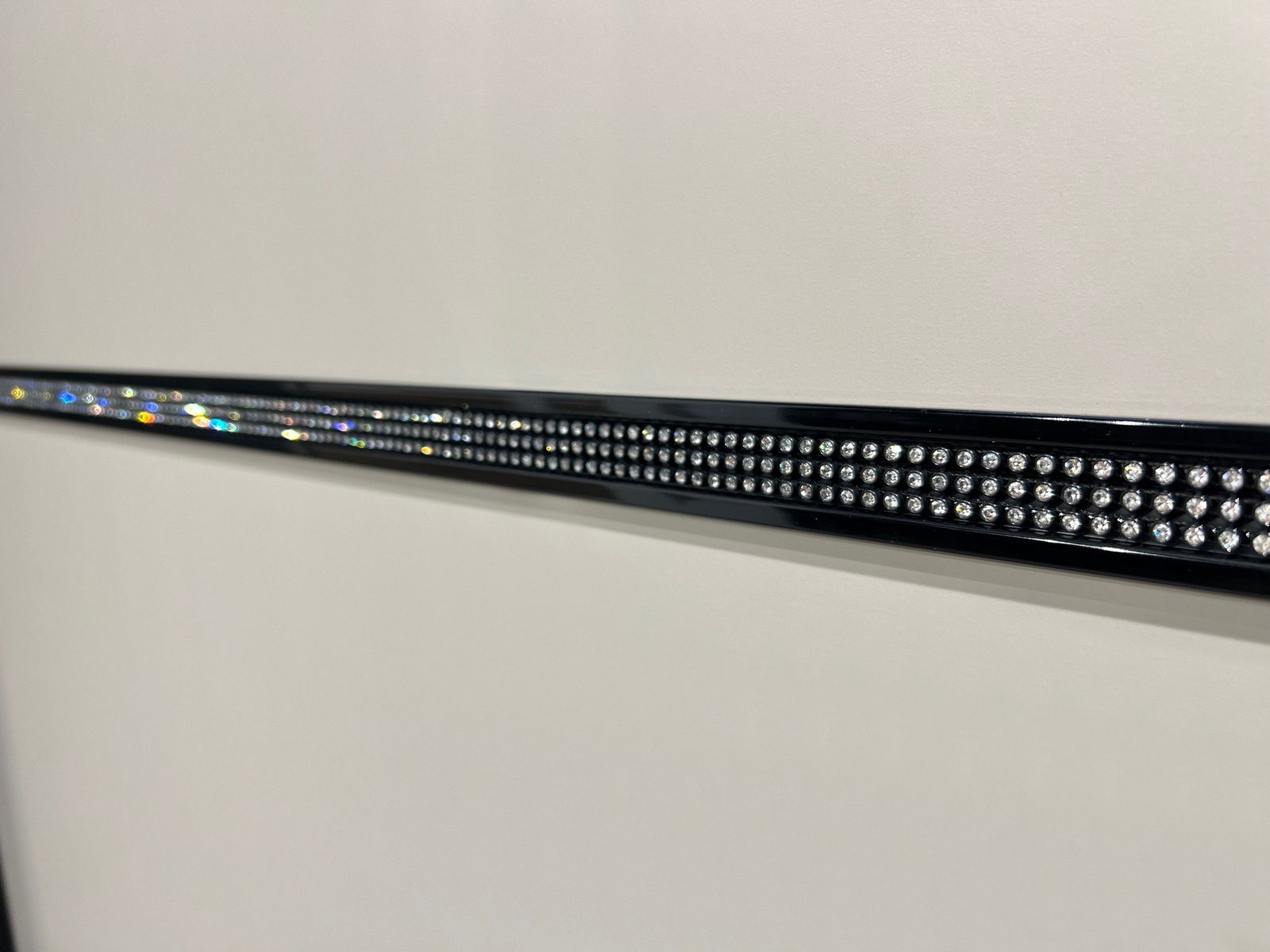 Nahaufnahme eines Schwebetürenschranks mit glänzender Zierleiste, seitliche Perspektive