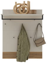 Garderobenpaneel mit Haken, Ablage und Dekoration, frontal betrachtet. Ein grüner Mantel und eine beige Tasche hängen an den Haken.