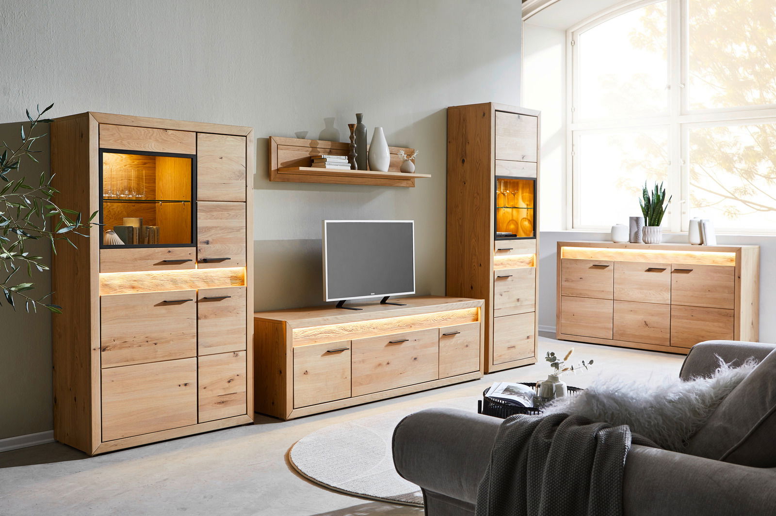 Wohnzimmermöbel-Set aus Holz mit Beleuchtung, bestehend aus Vitrinen, Lowboard und Sideboard, seitliche Perspektive